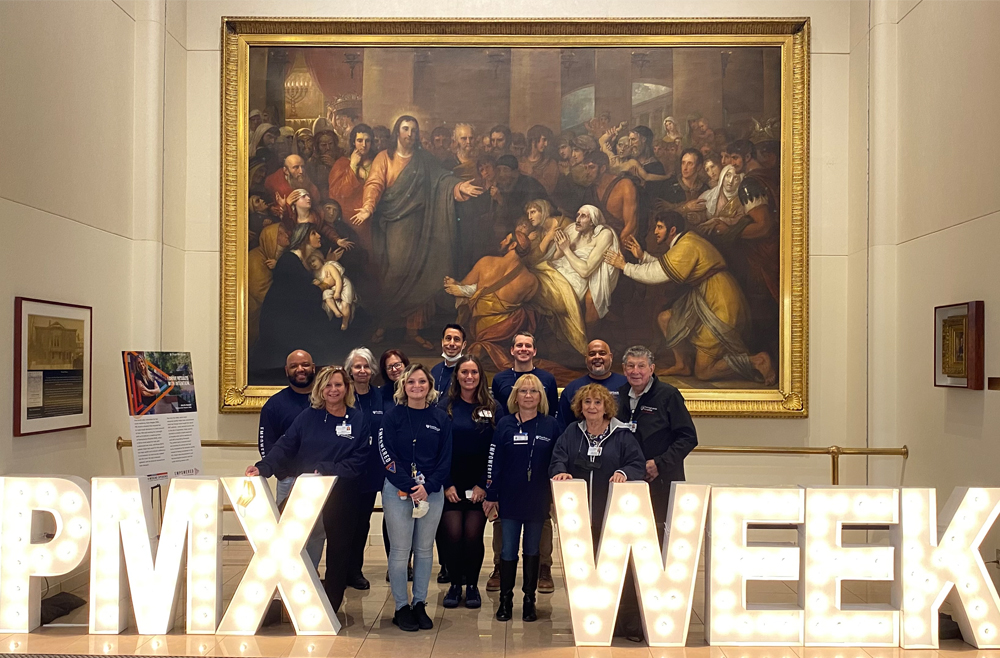 Patient and Family Advisory Council members pose next to PMX Week sign